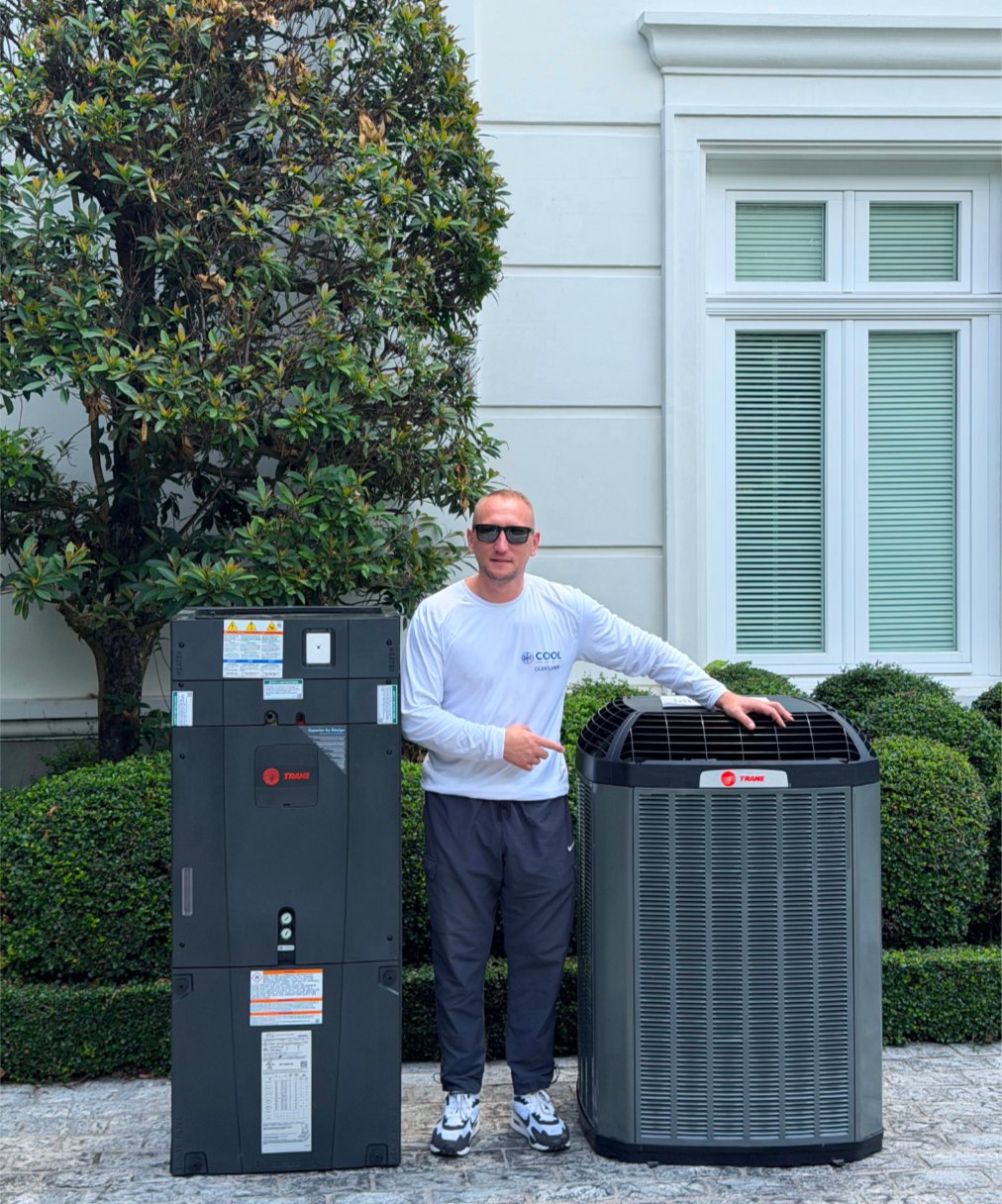 Cool Comfort Service technician standing between a new Trane air handler and outdoor unit